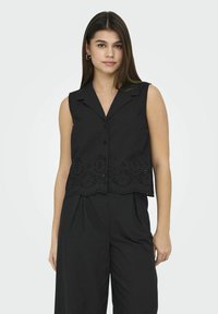 Blusa nera senza maniche con colletto, dotata di un orlo ricamato a taglio e chiusura con bottoni frontali, realizzata in tessuto leggero.