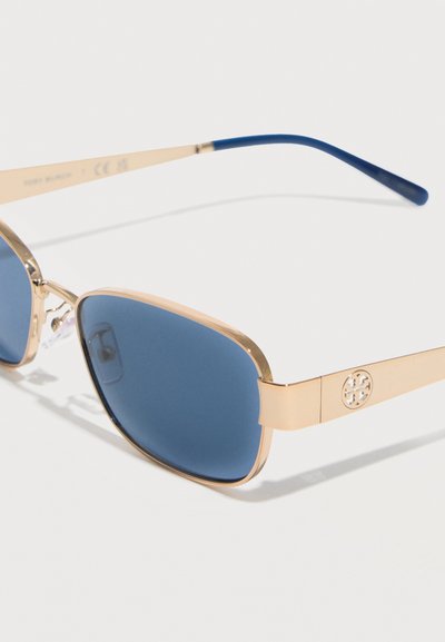 Γυαλιά ηλίου με χρυστό μεταλλικό σκελετό, μπλε ορθογώνιους φακούς και ναυτικό μπλε άκρα βραχιόνων, με στρογγυλό λογότυπο στα βραχίονες.