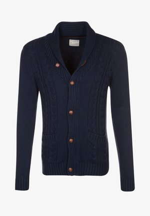 Cardigan a maglia a trecce blu navy con collo a scialle, bottoni marroni e due tasche anteriori.