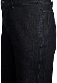 Los jeans de mezclilla oscura presentan un diseño de pierna recta con una textura suave. Las costuras visibles y un bolsillo lateral mejoran la funcionalidad.