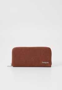 Brown suede wallet with embossed circular patterns, zip closure, and silver hardware. Features a logo on the bottom right corner.