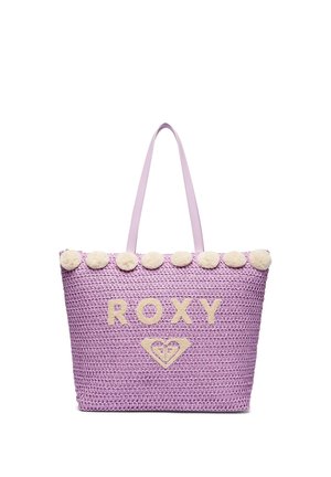 Lavendel-farvet vævet tote taske med creme pomponer langs topkanten, cremefarvet "ROXY" tekst og hjerte-logo foran med matchende lavendel håndtag.