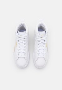 Bílé vysoké tenisky s plochými tkaničkami, hladkým koženým svrškem, zlatými akcenty a strukturovanou špičkou. Vnitřek má polstrovanou podšívku.