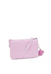 Borsa a tracolla in tessuto rosa con finitura testurizzata, chiusura con zip, tracolla regolabile e un accento di pom-pom pendente.