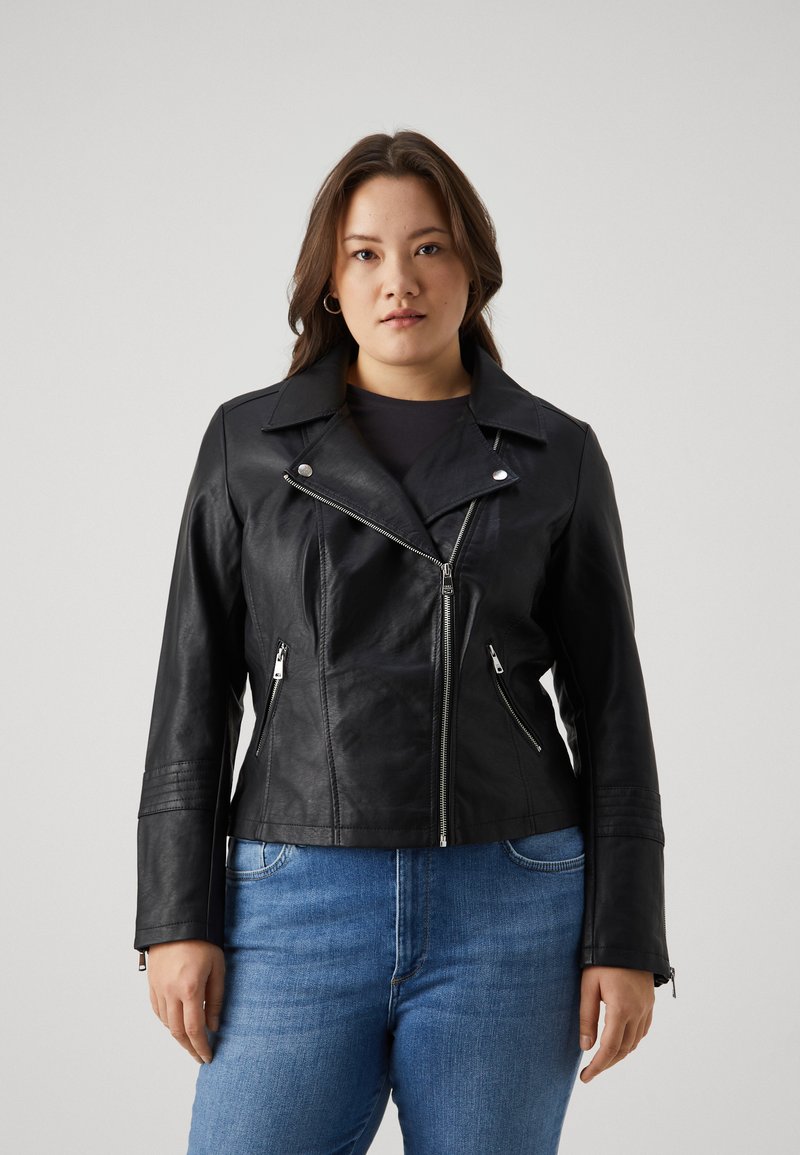 Black leather biker jacket features a pointed collar, silver zip closures, and fitted silhouette with zipper pockets, paired with blue jeans.