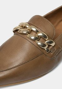 Brune læder loafers med en guld kæde accent over toppen. Har et elegant design med glat tekstur og detaljeret syning.