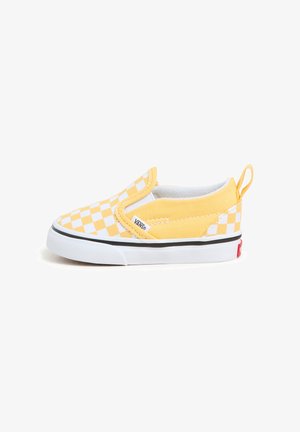 Žluté slip-on tenisky s kostkovaným vzorem, plátěným materiálem, bílými akcenty a černou gumovou podrážkou s poutkem vzadu.