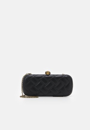 Pochette noire matelassée aux bords arrondis, bandoulière chaîne dorée et fermoir décoratif doré en forme de tête d’animal sur fond blanc.