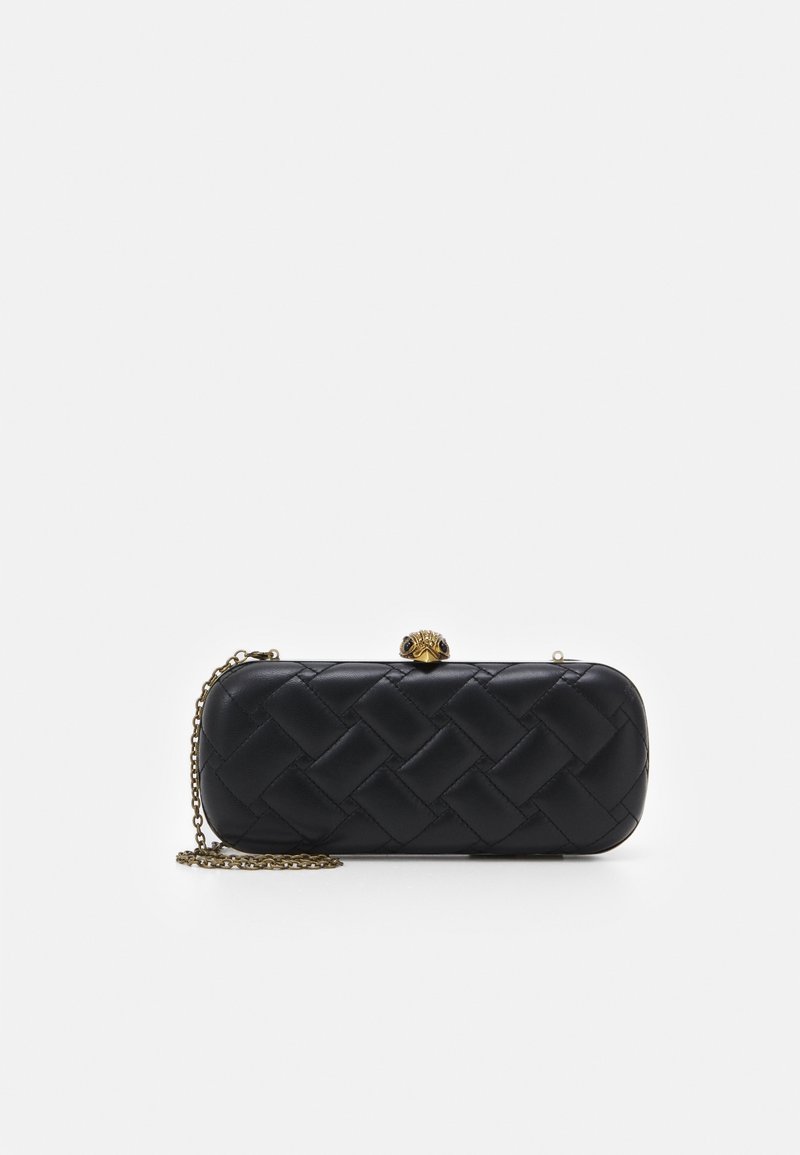 Pochette noire matelassée aux bords arrondis, bandoulière chaîne dorée et fermoir décoratif doré en forme de tête d’animal sur fond blanc.