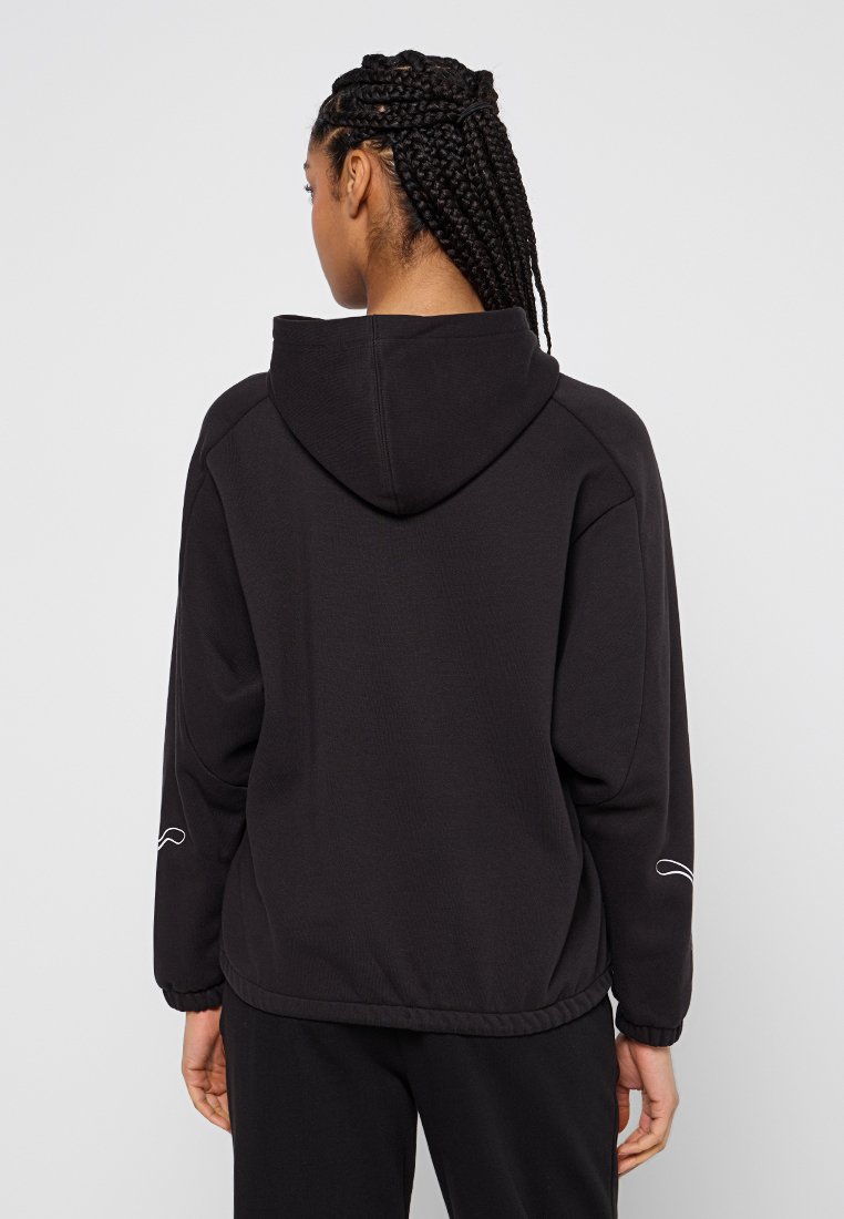 Sudadera con capucha negra de corte relajado. Tejido texturizado y puños de canalé, con un sutil detalle de línea blanca en la manga izquierda.