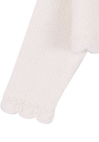 Une paire de collants pour bébé blancs texturés avec des bords en forme de coquille aux chevilles sur un fond blanc.
