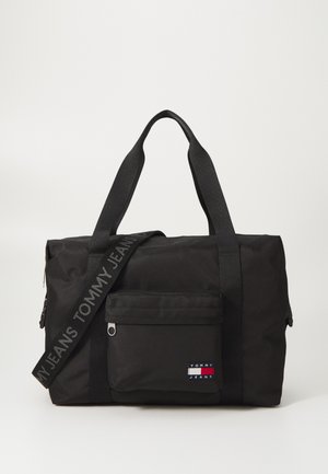 Black duffel bag made of durable fabric, featuring a front zip pocket, reinforced handles, and a branded shoulder strap.