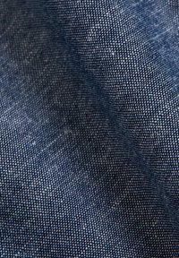 Getextureerde blauwe stof met een geweven patroon, bestaande uit een mix van donkere en lichte draden voor diepte en visuele interesse.