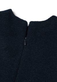 Donker marineblauwe wollen kledingstuk met een hoge hals en een ritsdetail op de achterkant. De textuur is zacht met een licht fuzzy uiterlijk.