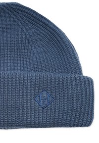 Virkat mössa i mörkblått med ribbat mönster. Har en vikt kant och en broderad diamantlogotyp i matchande blå nyans.