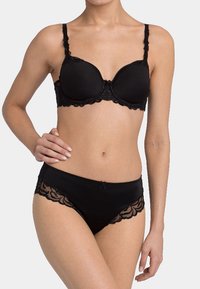 Černý komplet spodního prádla obsahující vyztuženou podprsenku s krajkovým lemem a nastavitelnými ramínky, doplněný odpovídajícími kalhotkami ve stylu bikini s krajkovými detaily.