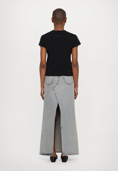 Black fitted t-shirt paired with a long, light blue denim skirt featuring a center slit, visible stitching, and two back pockets.