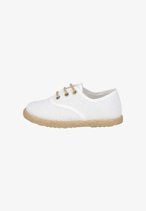 Zapatilla casual de lona blanca con suela tejida beige y tres ojales con cordones de color natural, vista lateral sobre fondo blanco.