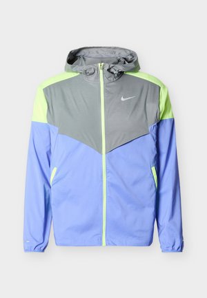 Pánska vetrovka s kapucňou, farebne rozdelená na sivú, neonovo žltú a svetlomodrú, so zipsom vpredu a logom Nike na hrudi.