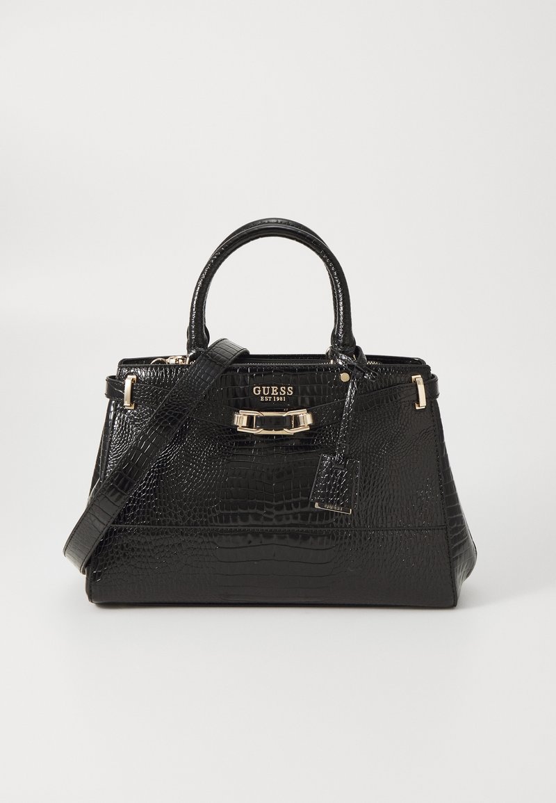 Sac à main Guess noir en cuir synthétique effet crocodile avec poignées supérieures, bandoulière amovible, ferrures dorées et détail du logo à l'avant.