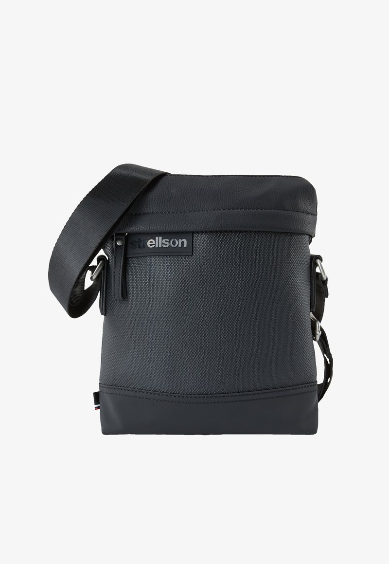 Mustassa viestintälaukussa on teksturoitu materiaali, säädettävä hihna, yläpuolen läppäkiinnitys ja etuosassa logo-patch. Sujuva pohjaosuus.