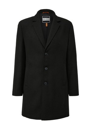 Juodas vilnos derinio paltas su įpjovimu apykakle, priekyje užsegamas mygtukais, su dviem šoniniais kišenėmis ir lygiu paviršiumi. Pati paltas turi oranžinę vidinę etiketę.