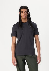 Dunkelgraues T-Shirt mit Rundhalsausschnitt aus weichem Stoff, kurz�ärmlig; mit einem minimalistischen Logo auf der linken Brust.