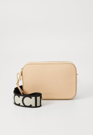Bolsa de couro bege com acabamento texturizado, apresentando um fecho dourado e uma alça preta com letras brancas. Forma retangular, design compacto.
