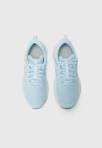 Chaussures de sport bleu clair avec tige en maille et semelles blanches, vues du dessus, avec lacets et logo sur la semelle intérieure.