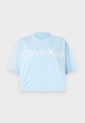 Lyseblå cropped t-skjorte i myk bomull, med rund hals, korte ermer og markant hvit tekst "Calvin Klein" foran.