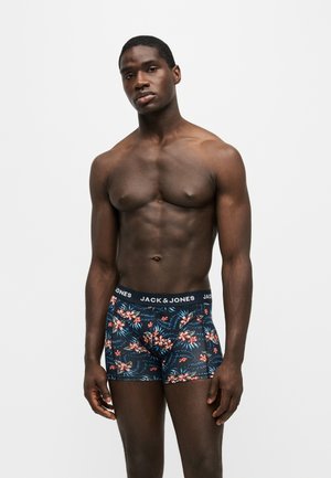 Homme musclé portant un boxer sombre avec un motif floral rouge et blanc et une ceinture noire avec le logo Jack & Jones.