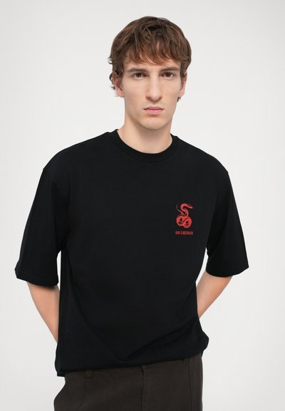 Schwarzes T-Shirt aus Baumwolle, mit einem roten Schlangengrafik und Text auf der Brust, kurzer Ärmel und Rundhalsausschnitt.