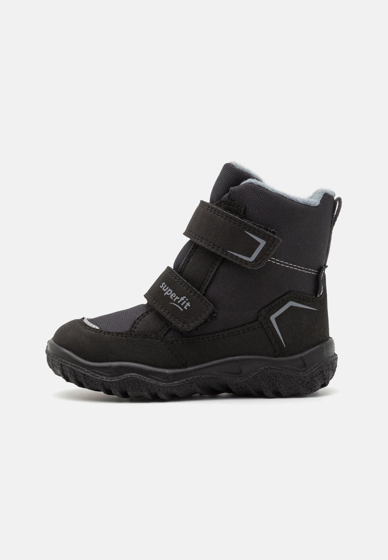 Botte d'hiver pour enfants noirs en textile et matériau synthétique, avec des sangles Velcro et une semelle robuste au motif texturé.