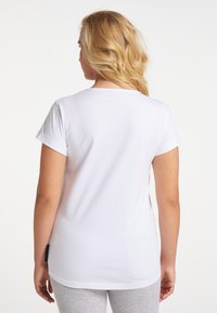 Weißes kurzärmeliges T-Shirt mit entspannter Passform, Rundhalsausschnitt und aufgerollten Ärmeln, aus weicher Baumwolle.