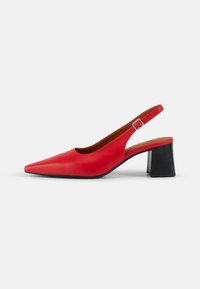 Red leather slingback shoe with pointed toe, black stacked heel, and adjustable buckle strap. Smooth texture and minimal design.