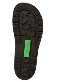 Suela de zapato de goma negra con patrones texturizados para un buen agarre. Una etiqueta verde dice "El Naturalista" cerca del centro.