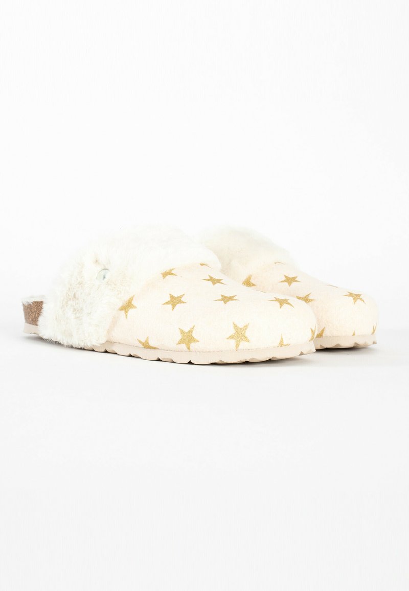 Cremfarbene Hausschuhe zum Hineinschlüpfen mit goldenen Sterne-Mustern und flauschigem weißen Fellbesatz auf einem weißen Hintergrund.