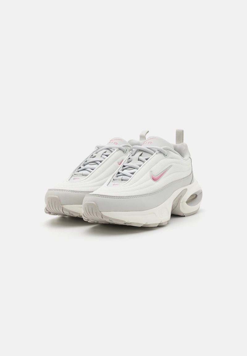 Scarpe sportive bianche e grigie con dettagli rosa, dotate di tomaia in rete, punta arrotondata e ammortizzazione ad aria visibile nella suola.