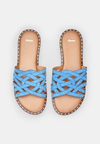 Sandale slide din suede albastru cu un design crisscross. Talpa maro este accentuată cu studs aurii. Interiorul are un finisaj neted de culoare maroniu deschis.
