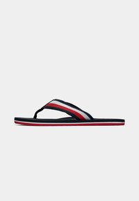 Sandale flip-flop cu bretele din țesătură în dungi roșii, albe și bleumarin și o talpă coordonată cu dungi, prezentată din lateral pe un fundal simplu.