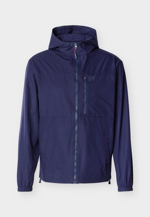 Tumesinise kapuutsiga jope esilise luku, elastsete mansettide, lukuga rinnatasku ja reguleeritavate alumiste nööridega, valgel taustal.