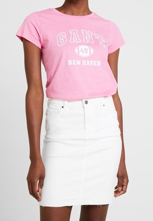 Roze katoenen t-shirt met de opdruk "GANT 49 NEW HAVEN", gecombineerd met een witte denim rok met een hoge taille en een onafgewerkte zoom.