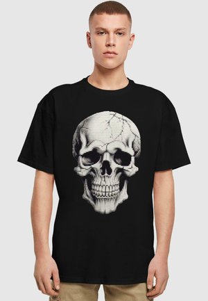 Sort T-shirt med et fremtrædende hvidt kranie grafik med pixeliserede detaljer. Korte ærmer, rund hals, afslappet pasform.