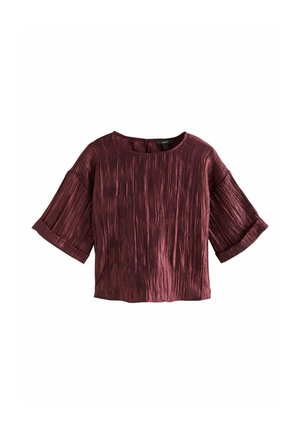 Burgundijas krāsas croptops ar apaļu kaklu, teksturētu audumu un platām krokotām piedurknēm, kuram ir vienkārša krāsa ar smalkām līnijām.