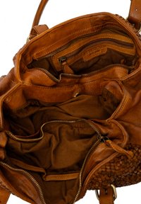 Borsa a mano in pelle marrone aperta per mostrare più scomparti con zip e rivestimento in tessuto all'interno.