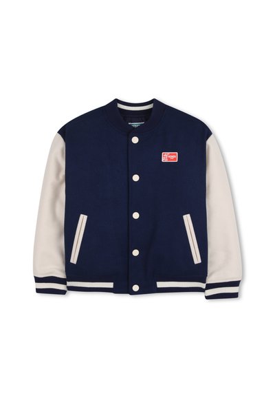 Marineblauw varsityjack met crèmekleurige mouwen, geribbelde manchetten en kraag. Voorzien van een rood logo patch en witte drukknopen. Gevoerd met gestructureerde stof.