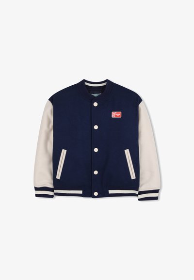 Marineblauw varsityjack met crèmekleurige mouwen, geribbelde manchetten en kraag. Voorzien van een rood logo patch en witte drukknopen. Gevoerd met gestructureerde stof.