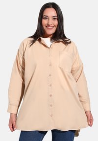 Camicia a maniche lunghe di colore pesca chiaro, realizzata in tessuto morbido, con apertura a bottoni, colletto, taschino singolo e vestibilità rilassata.