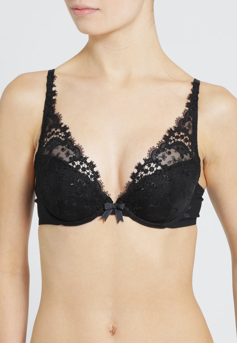 Black lace bra featuring sheer panels, floral embroidery, and adjustable straps. Decorated with a small satin bow at the center.