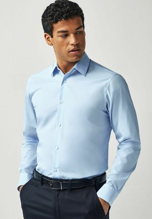 Himmelblaues Hemd mit spitzen Kragen, langen Ärmeln und Knopfleiste. Glatte Textur und slim fit Details.
